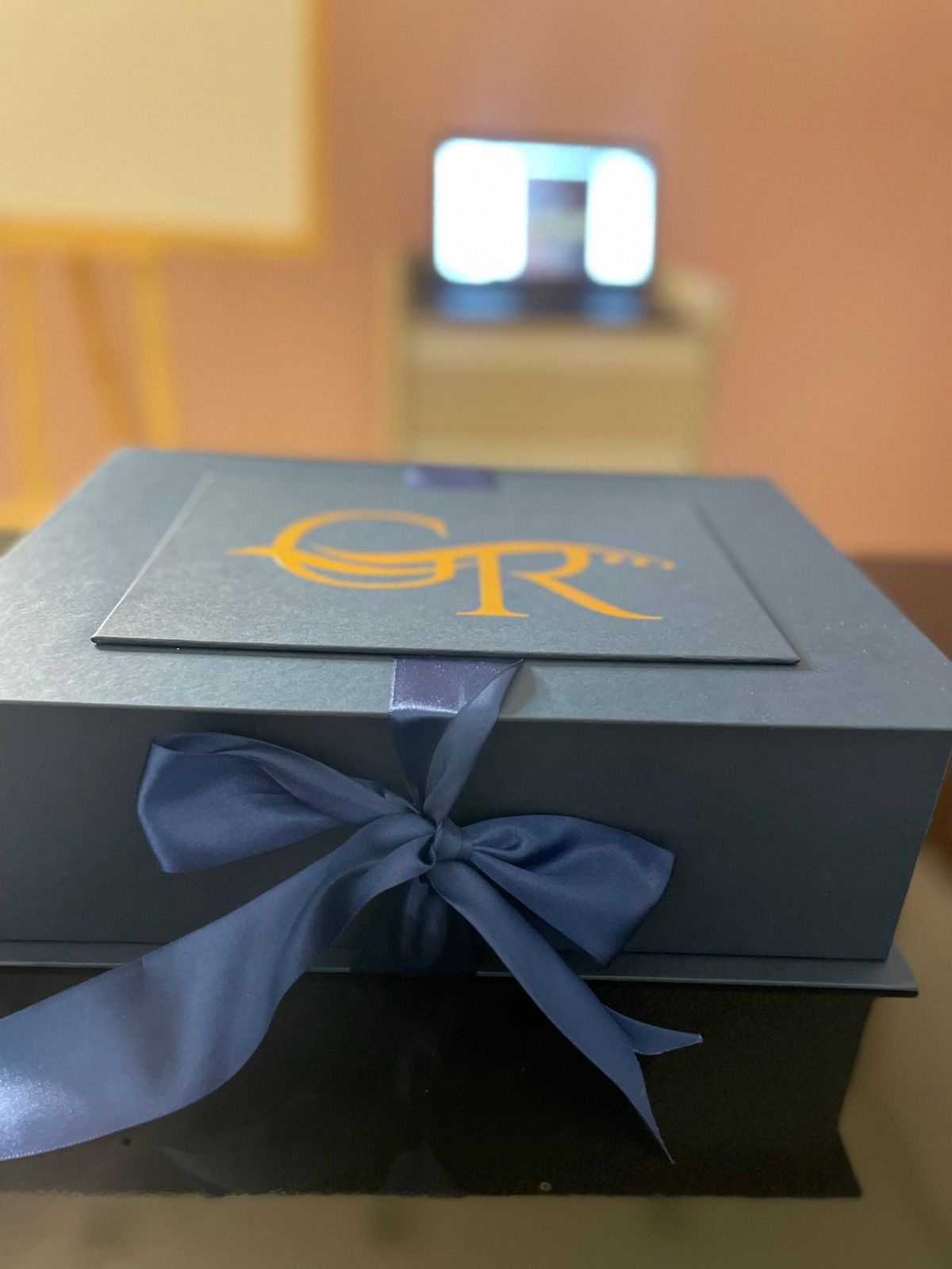 Caixa presente Geyze Rodrigues em azul marinho com logo dourado