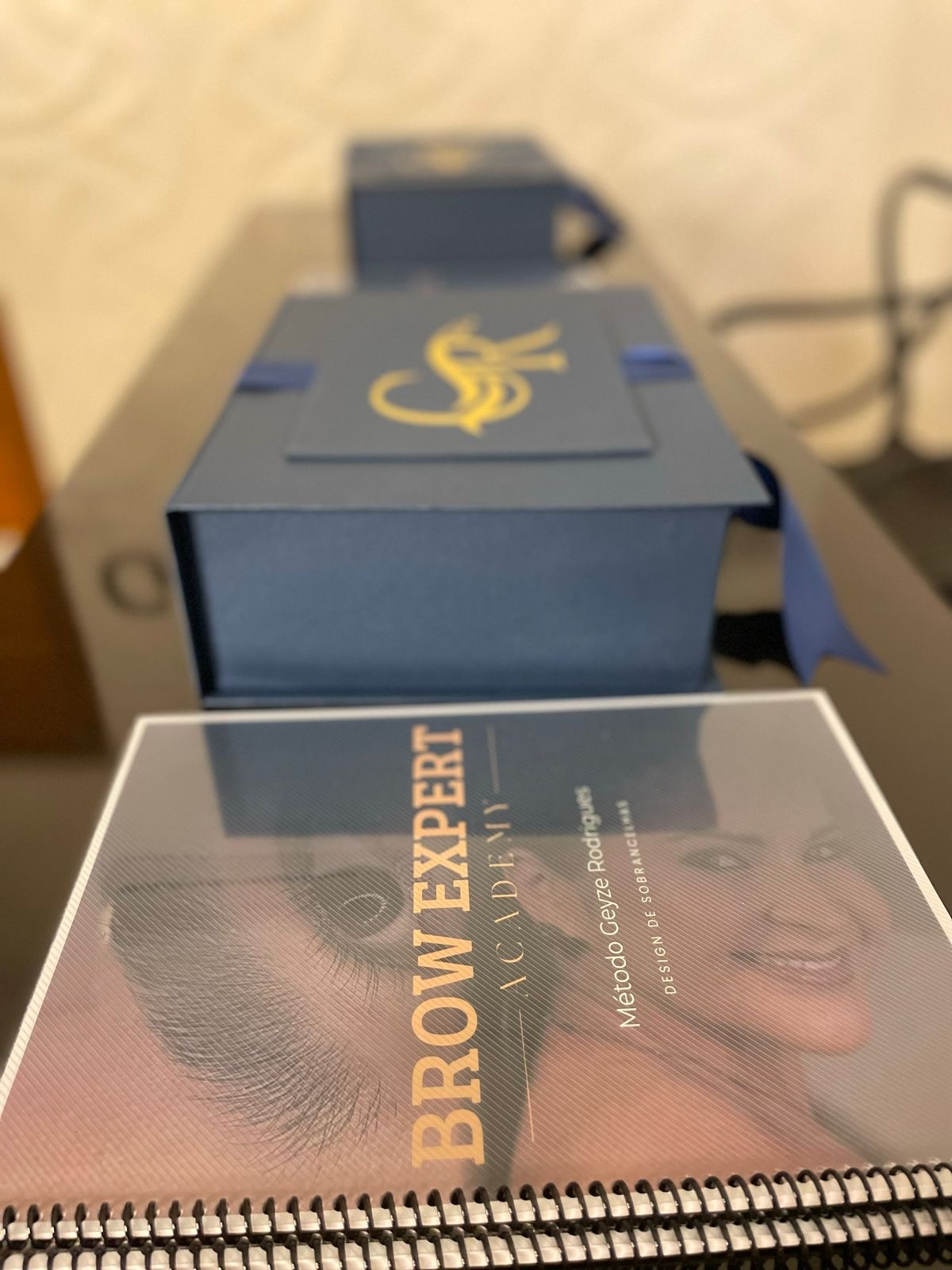 Apostila Brow Expert Academy ao lado do kit presente